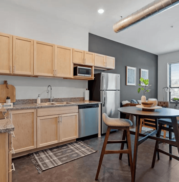 a kitchen with wooden cabinets and a table and chairs
